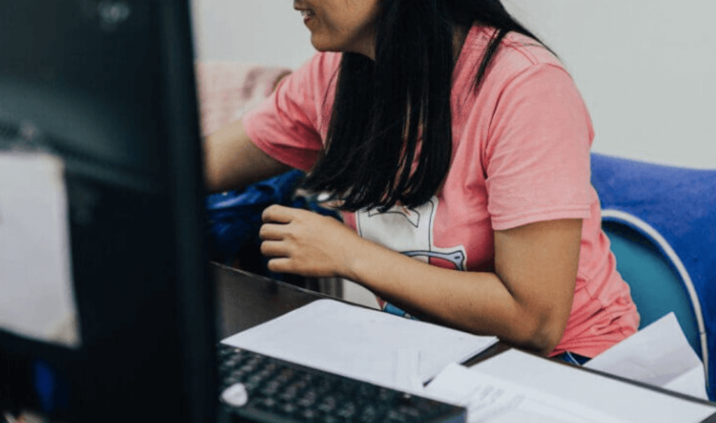 woman smiles while working on computer